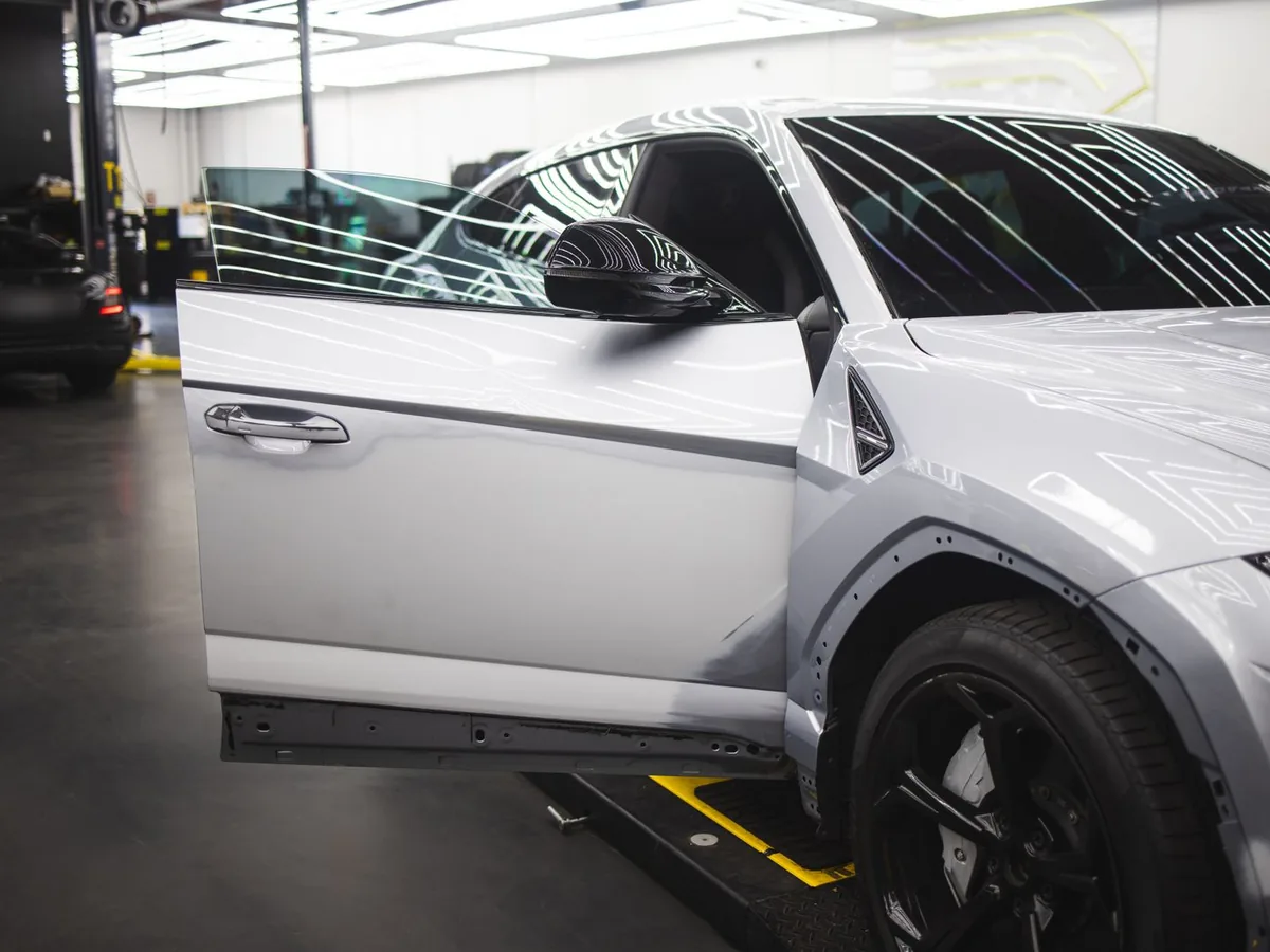 Véhicule gris en réparation de carrosserie dans un atelier lumineux