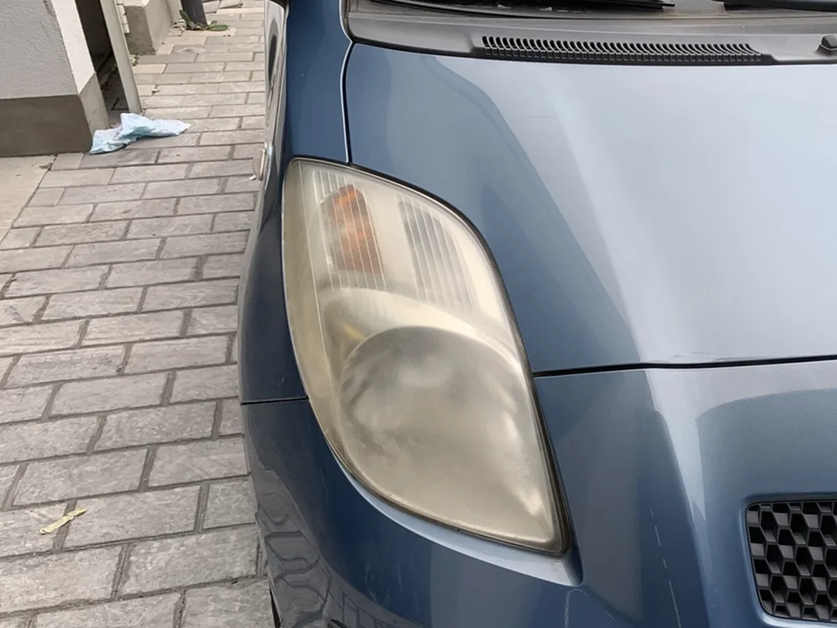 Avant : optique avant jauni et terne d'une Toyota Yaris bleue